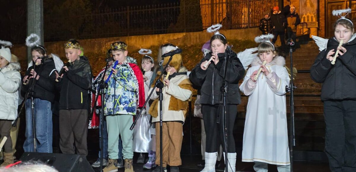 Uczniowie Szkoły Podstawowej nr 6 występujący podczas wydarzenia świątecznego. Dzieci przebrane za anioły i kolędników grają na fletach na scenie plenerowej.