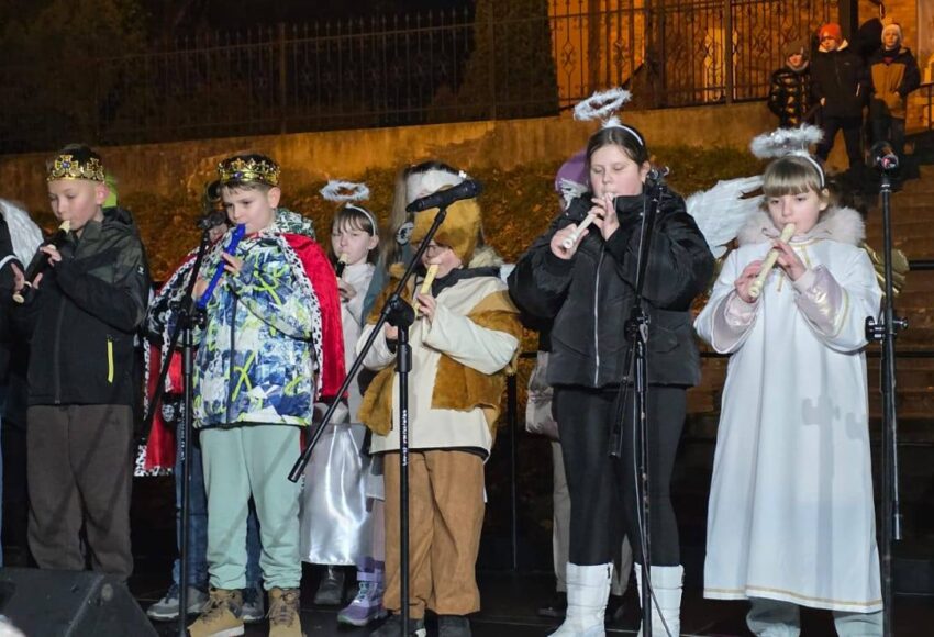 Uczniowie Szkoły Podstawowej nr 6 występujący podczas wydarzenia świątecznego. Dzieci przebrane za anioły i kolędników grają na fletach na scenie plenerowej.