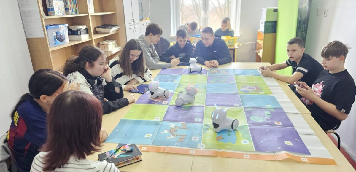 Uczniowie klas IV i VII podczas zajęć w Laboratorium Przyszłości pracują z robotami Photon, programując ich ruch na edukacyjnej macie.