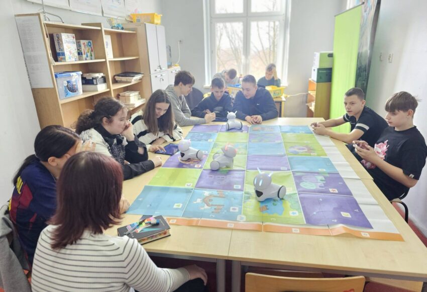 Uczniowie klas IV i VII podczas zajęć w Laboratorium Przyszłości pracują z robotami Photon, programując ich ruch na edukacyjnej macie.