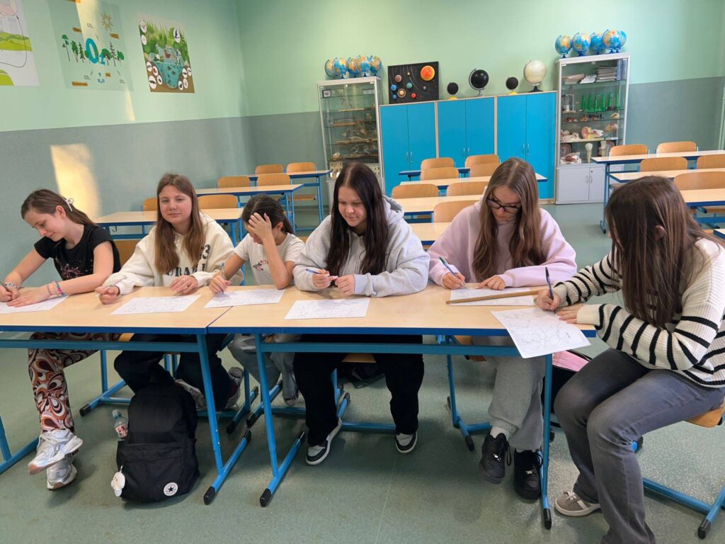 Uczennice z grupy „Eko-Ja” podczas zajęć ekologicznych w sali lekcyjnej pracują nad kartami zadań w ramach programu EduAkcja