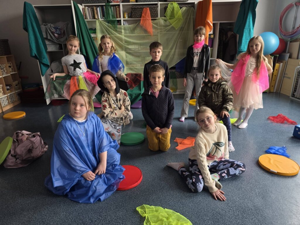 Uczniowie klasy 2 w kolorowych strojach podczas przedstawienia „Szafantura” z okazji pierwszego dnia wiosny.