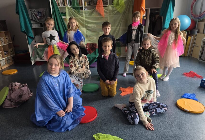 Uczniowie klasy 2 w kolorowych strojach podczas przedstawienia „Szafantura” z okazji pierwszego dnia wiosny.