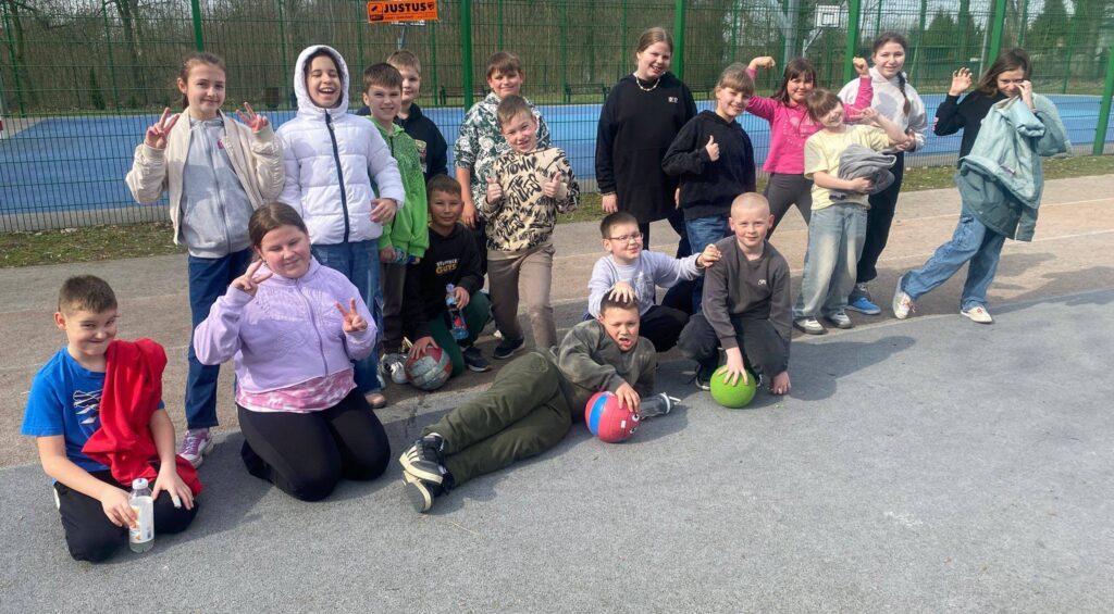 Uczniowie klasy 4a podczas wiosennego spaceru i aktywności na świeżym powietrzu na szkolnym boisku.
