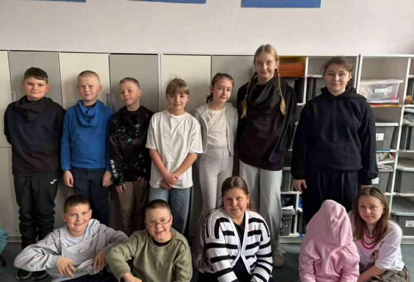 Uczniowie szkoły pozujący wspólnie w klasie podczas Szalonego Wiosennego Tygodnia, prezentujący różnorodne stylizacje związane z jednym z dni tematycznych.