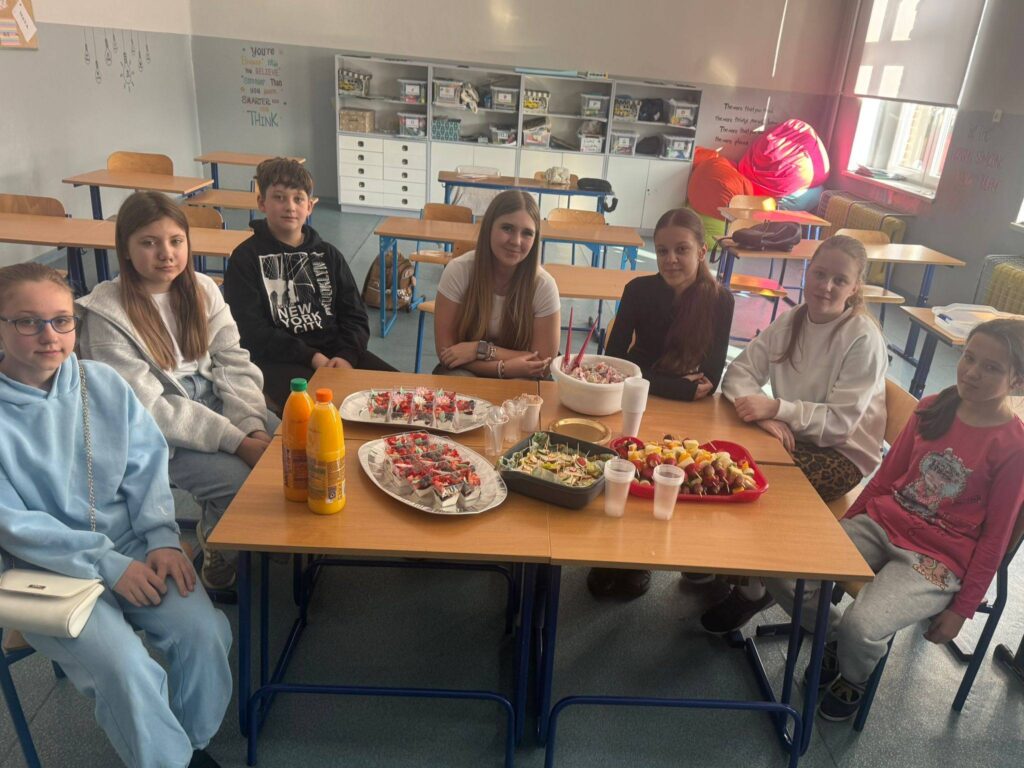 Uczniowie podczas zajęć programu „Trzymaj Formę” wspólnie przygotowują i degustują zdrowe przekąski w sali lekcyjnej.