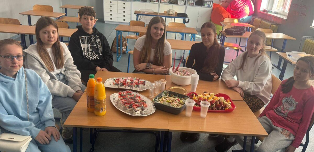 Uczniowie podczas zajęć programu „Trzymaj Formę” wspólnie przygotowują i degustują zdrowe przekąski w sali lekcyjnej.