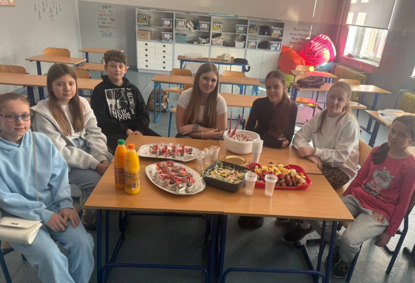 Uczniowie podczas zajęć programu „Trzymaj Formę” wspólnie przygotowują i degustują zdrowe przekąski w sali lekcyjnej.