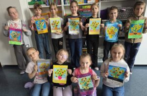 Uczniowie klasy drugiej prezentują wykonane prace plastyczne przedstawiające słoneczniki inspirowane twórczością Vincenta van Gogha