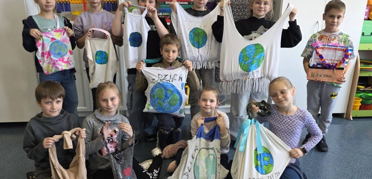 Uczniowie klasy 2 prezentują torby ekologiczne wykonane z materiałów z recyklingu z okazji Dnia Ziemi.