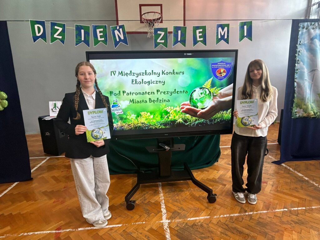 Uczennice klasy 8 prezentują dyplomy zdobyte podczas Międzyszkolnego Konkursu Ekologicznego.
