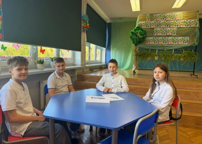 Uczniowie naszej szkoły podczas Powiatowego Konkursu Interdyscyplinarnego „InterGeniusze”, siedzą przy stoliku konkursowym.