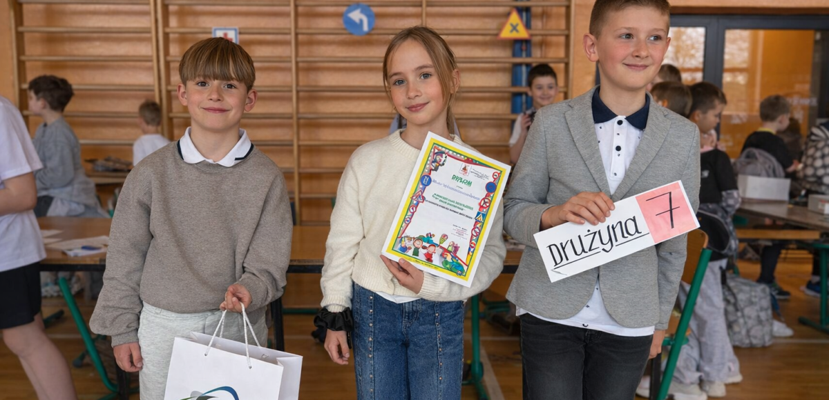 Uczniowie klasy trzeciej prezentują dyplom i oznaczenie drużyny podczas międzyszkolnego turnieju bezpieczeństwa.