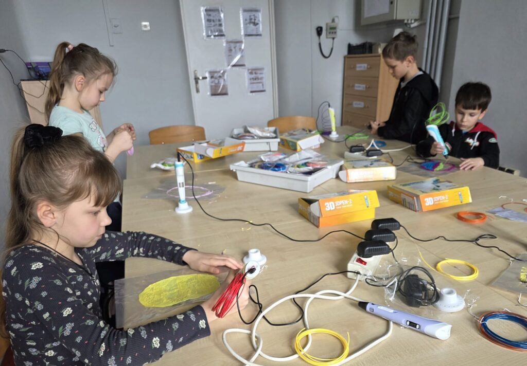 Uczniowie klas 1–3 podczas zajęć projektu „EduAkcja – Informatyka Europejczyka” tworzą wielkanocne pisanki przy użyciu długopisów 3D.
