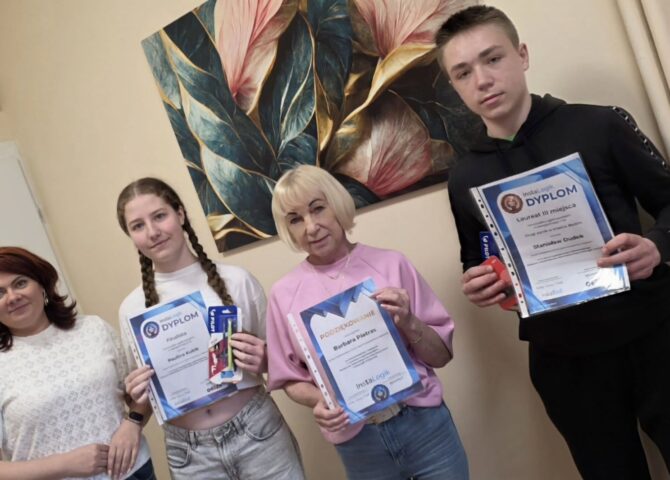 Uczniowie wraz z nauczycielami prezentują dyplomy i nagrody zdobyte w ogólnopolskim konkursie matematyczno-informatycznym InstaLogik.
