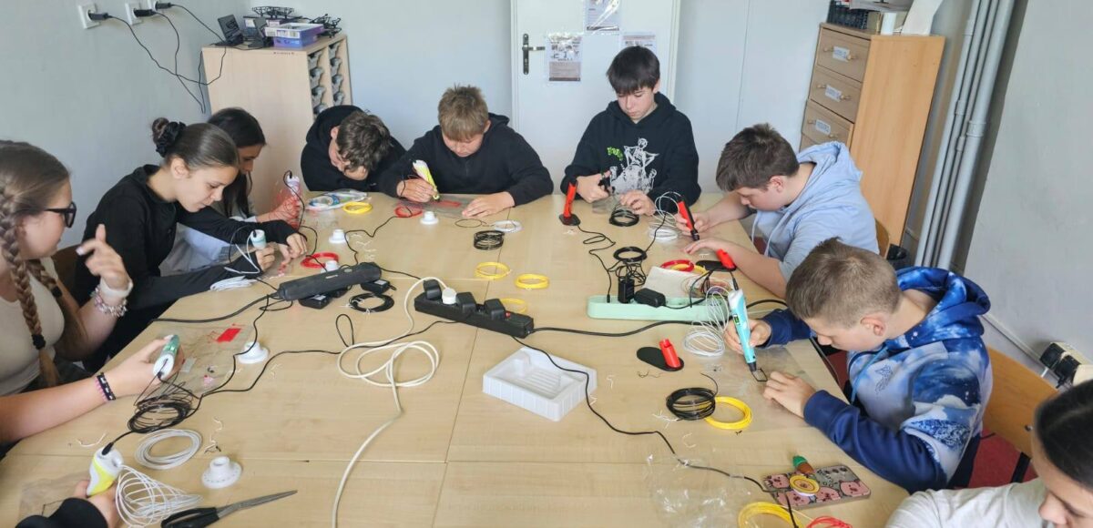 Uczniowie klas V–VI podczas zajęć w Laboratorium Przyszłości pracują z długopisami 3D