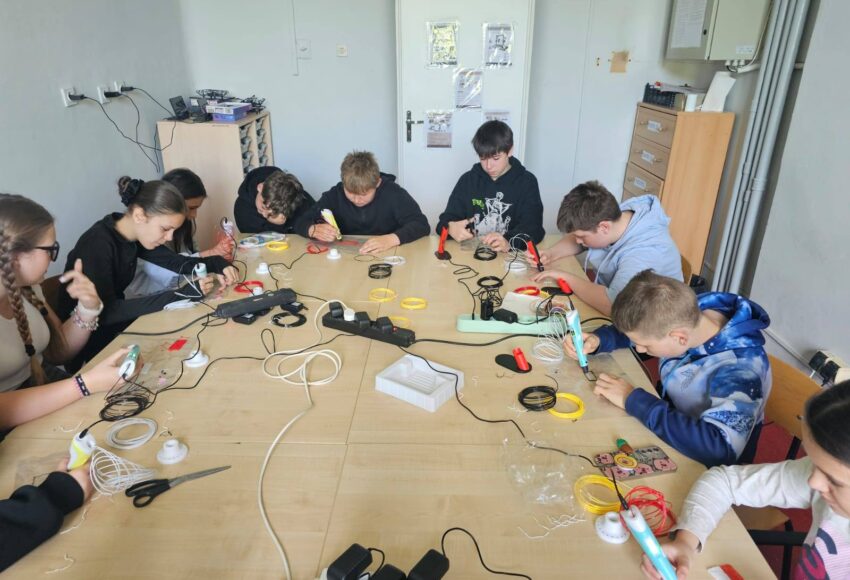 Uczniowie klas V–VI podczas zajęć w Laboratorium Przyszłości pracują z długopisami 3D