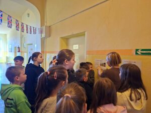 Uczniowie oglądają materiały edukacyjne o Londynie na szkolnym korytarzu podczas London Week