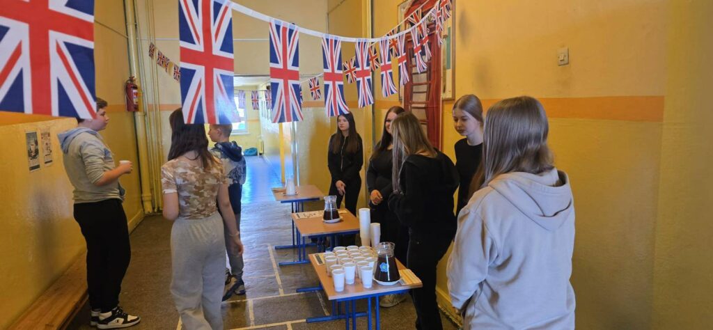 Uczniowie podczas degustacji herbaty w trakcie London Week na szkolnym korytarzu
