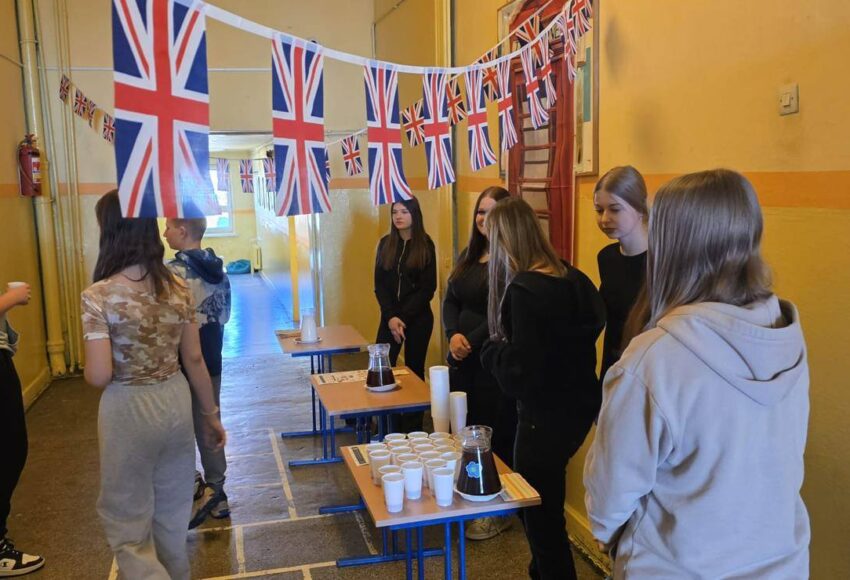 Uczniowie podczas degustacji herbaty w trakcie London Week na szkolnym korytarzu