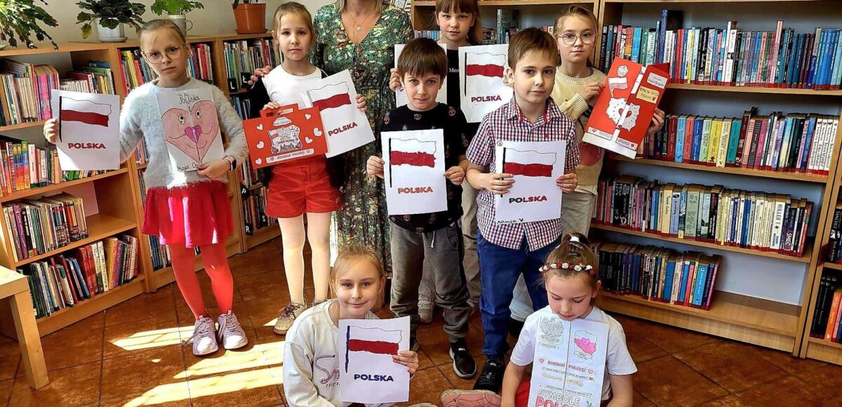 Uczniowie klasy II prezentują prace o polskich symbolach narodowych podczas zajęć w bibliotece