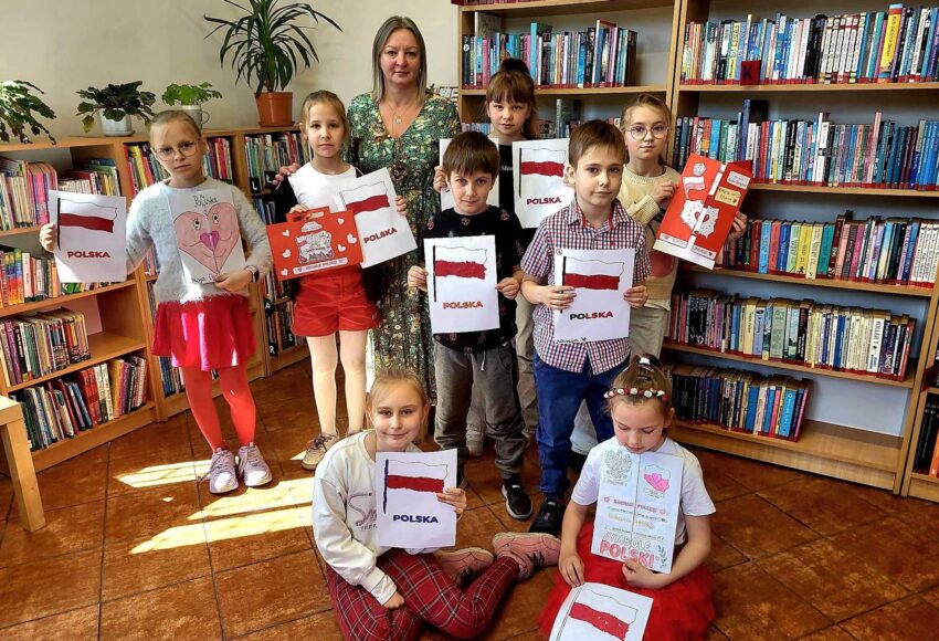 Uczniowie klasy II prezentują prace o polskich symbolach narodowych podczas zajęć w bibliotece