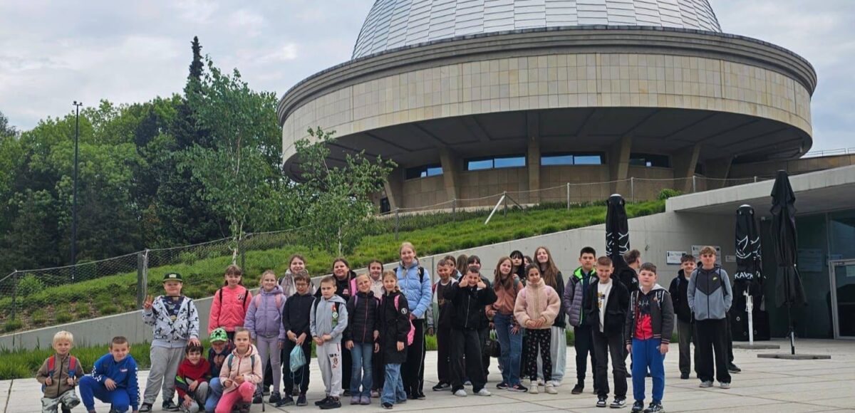 Uczniowie klas I–VIII podczas wycieczki do Planetarium – Śląskiego Parku Nauki w Chorzowie. Grupa stoi przed charakterystycznym budynkiem planetarium podczas realizacji projektu „EduAkcja”.