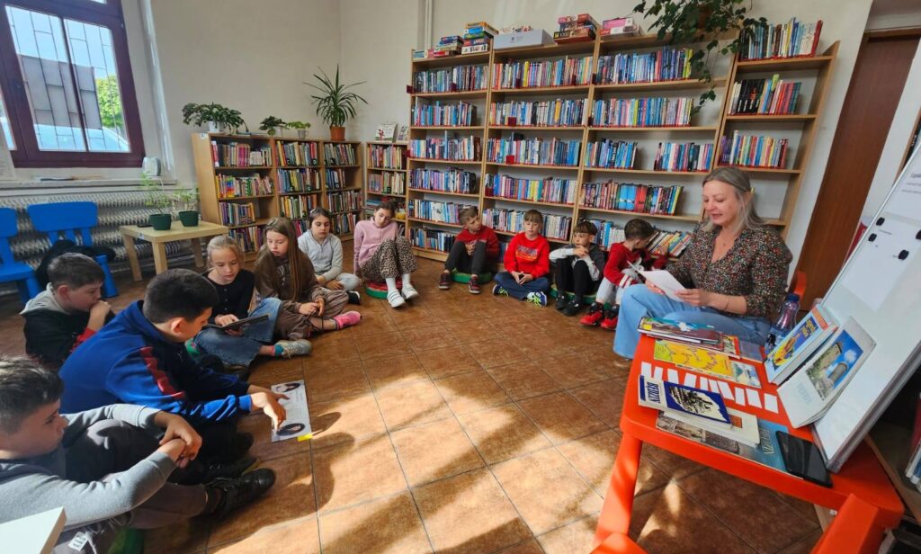 Uczniowie klasy III podczas lekcji bibliotecznej w Filii nr 5 Grodziec. Dzieci siedzą w kręgu i uczestniczą w zajęciach poświęconych polskim legendom oraz historii Będzina.