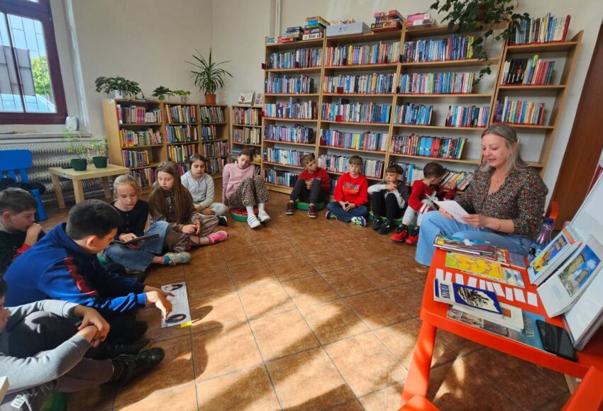 Uczniowie klasy III podczas lekcji bibliotecznej w Filii nr 5 Grodziec. Dzieci siedzą w kręgu i uczestniczą w zajęciach poświęconych polskim legendom oraz historii Będzina.
