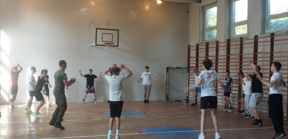Uczniowie uczestniczą w zajęciach sprawnościowych prowadzonych przez przedstawiciela oddziału wojskowego ZSOiT w Czeladzi podczas lekcji wychowania fizycznego.