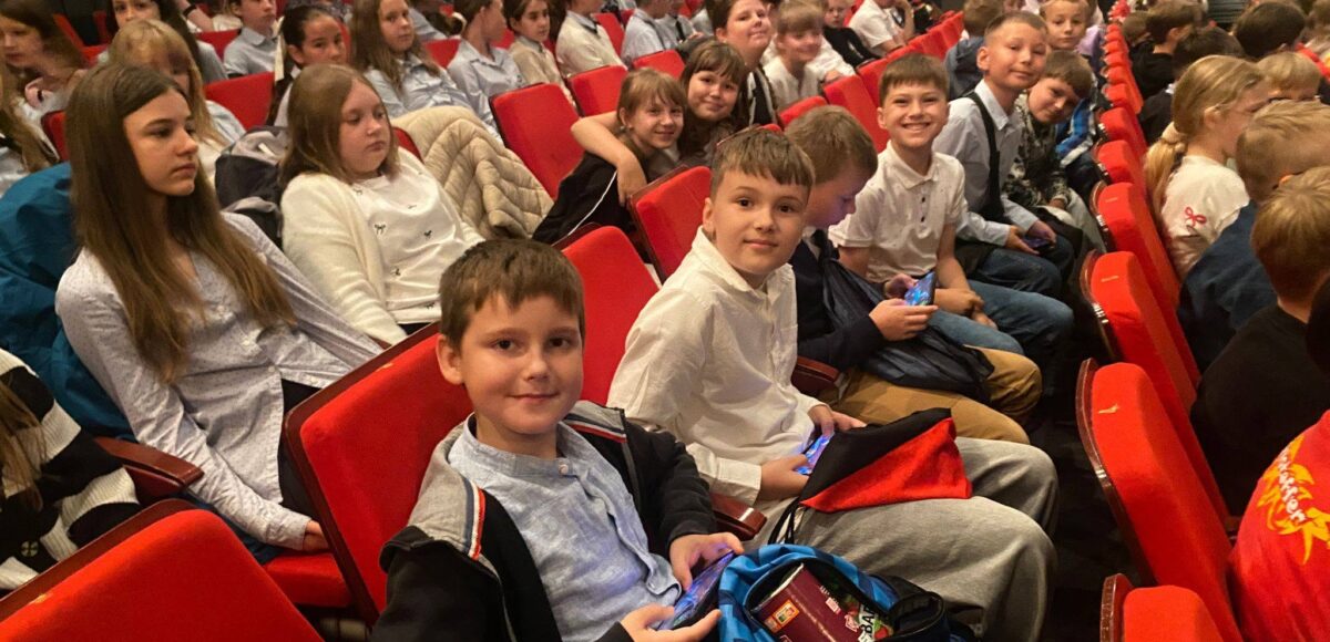 Uczniowie klas 4a i 5a siedzą na widowni Teatru Dzieci Zagłębia im. Jana Dormana w Będzinie przed rozpoczęciem spektaklu „Opowieści z Narnii. Lew, czarownica i stara szafa”