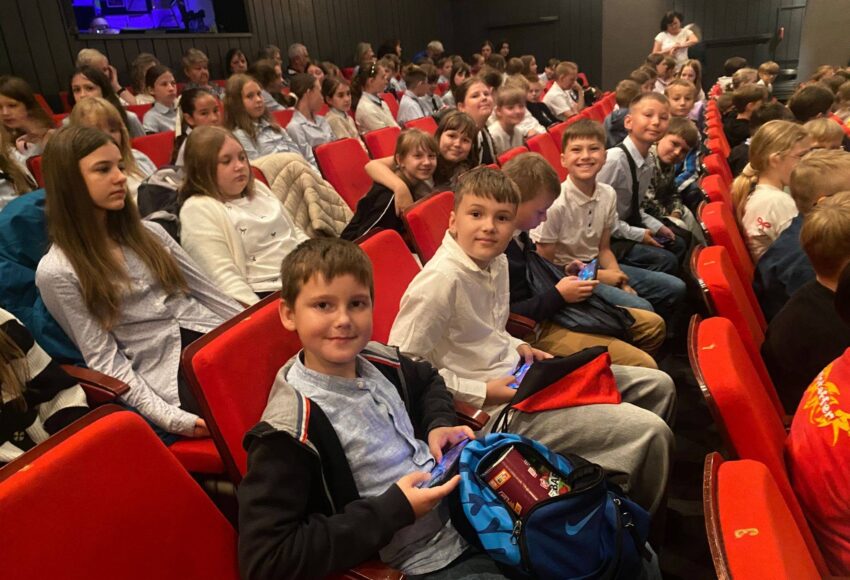 Uczniowie klas 4a i 5a siedzą na widowni Teatru Dzieci Zagłębia im. Jana Dormana w Będzinie przed rozpoczęciem spektaklu „Opowieści z Narnii. Lew, czarownica i stara szafa”
