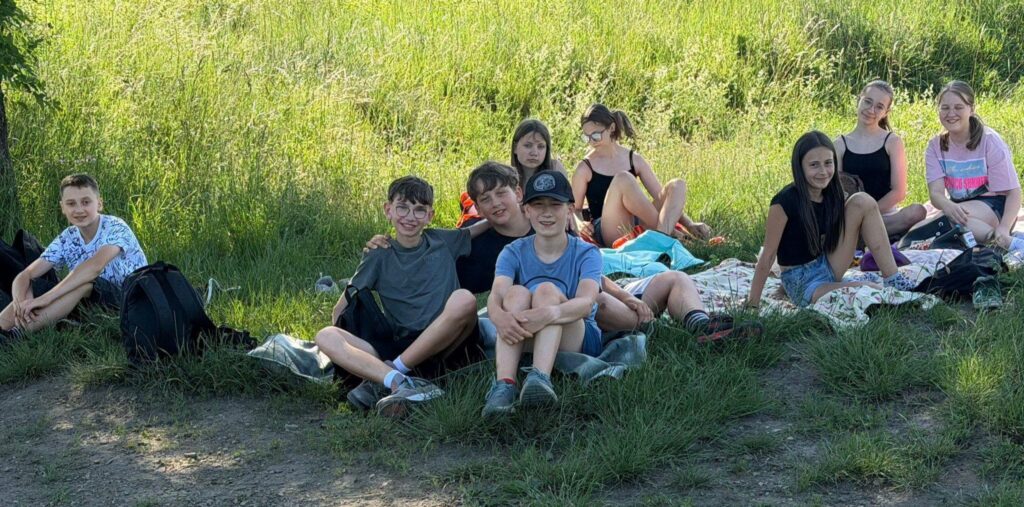 Uczniowie klasy VI odpoczywają na kocach podczas wspólnego wyjścia na Kamionkę w ostatnim dniu nauki.