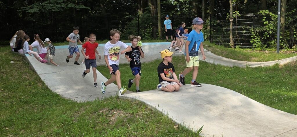 Uczniowie klas I–III aktywnie spędzają czas na skateparku w Parku Miejskim w Wojkowicach podczas szkolnej wycieczki.