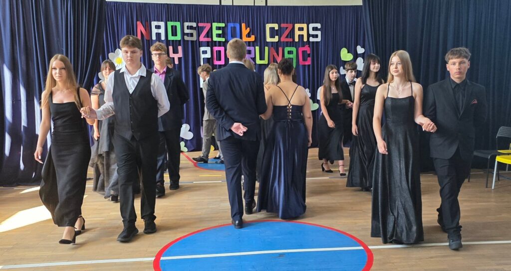 Uczniowie klasy VIII tańczą poloneza na zakończenie roku szkolnego.