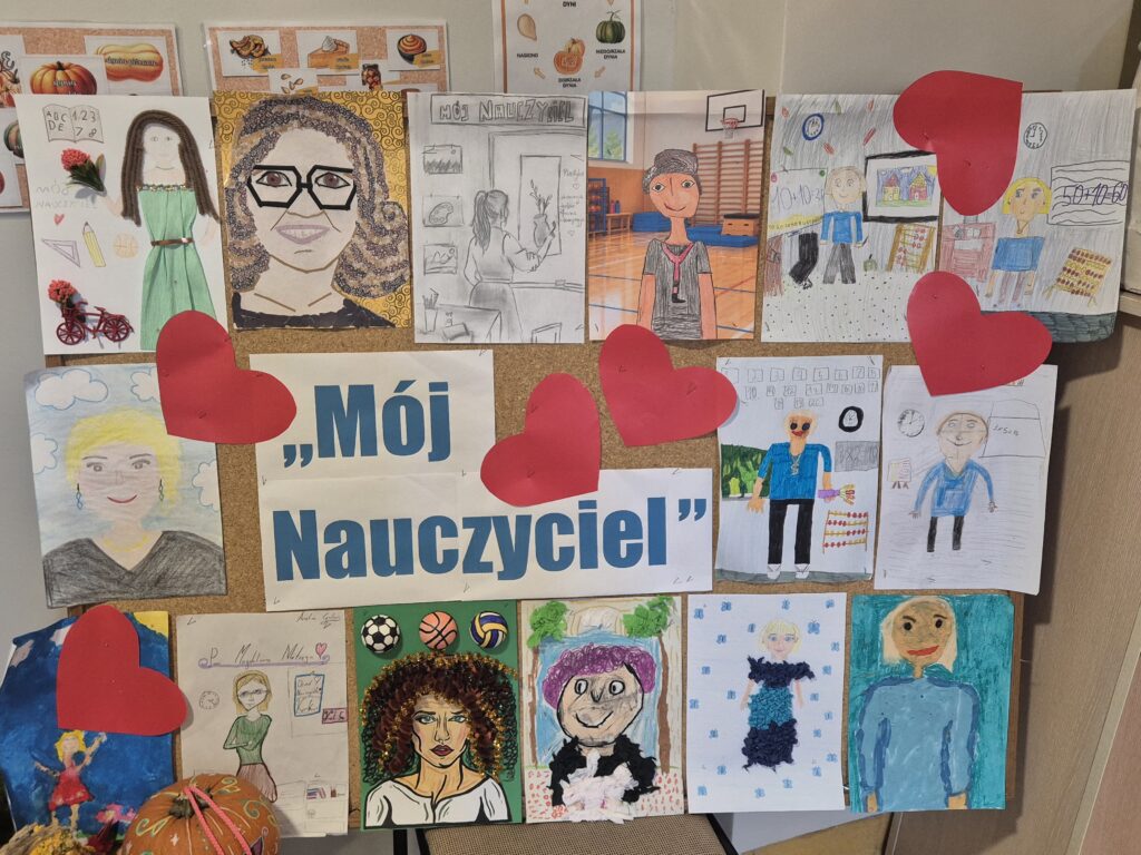 Tablica z wystawą prac plastycznych uczniów przygotowanych na konkurs „Mój Nauczyciel”. W centralnej części znajduje się tytuł konkursu, a wokół niego rozmieszczono kolorowe portrety nauczycieli wykonane różnymi technikami plastycznymi. Całość ozdobiona jest dużymi czerwonymi sercami.