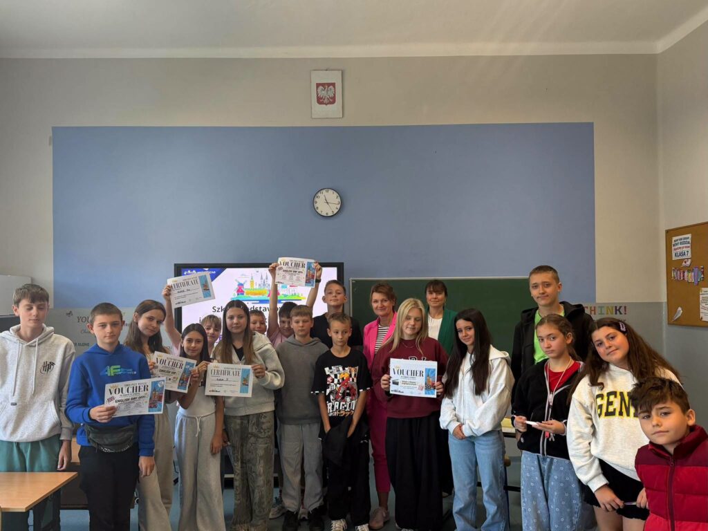 Zdjęcie grupowe uczestników Międzyklasowego Turnieju Europejskiego zorganizowanego w ramach obchodów Europejskiego Dnia Języków w Szkole Podstawowej nr 6 w Będzinie. Uczniowie prezentują otrzymane dyplomy i vouchery, a towarzyszą im nauczyciele oraz Pani Dyrektor.