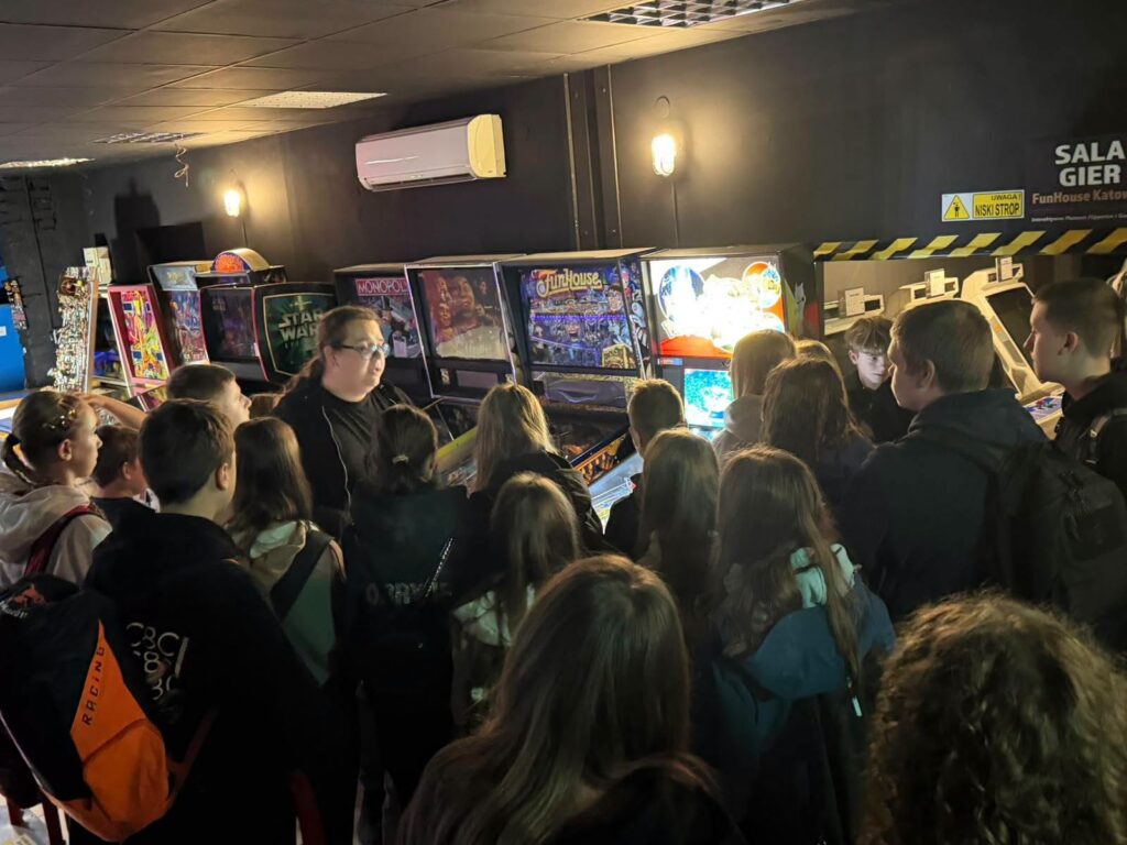 Uczniowie klas VII, VIIIa i VIIIb Szkoły Podstawowej nr 6 w Będzinie podczas wizyty w Interaktywnym Muzeum Flipperów i Gier Arcade FunHouse w Katowicach. Grupa poznaje historię gier i ogląda zabytkowe automaty do gry.